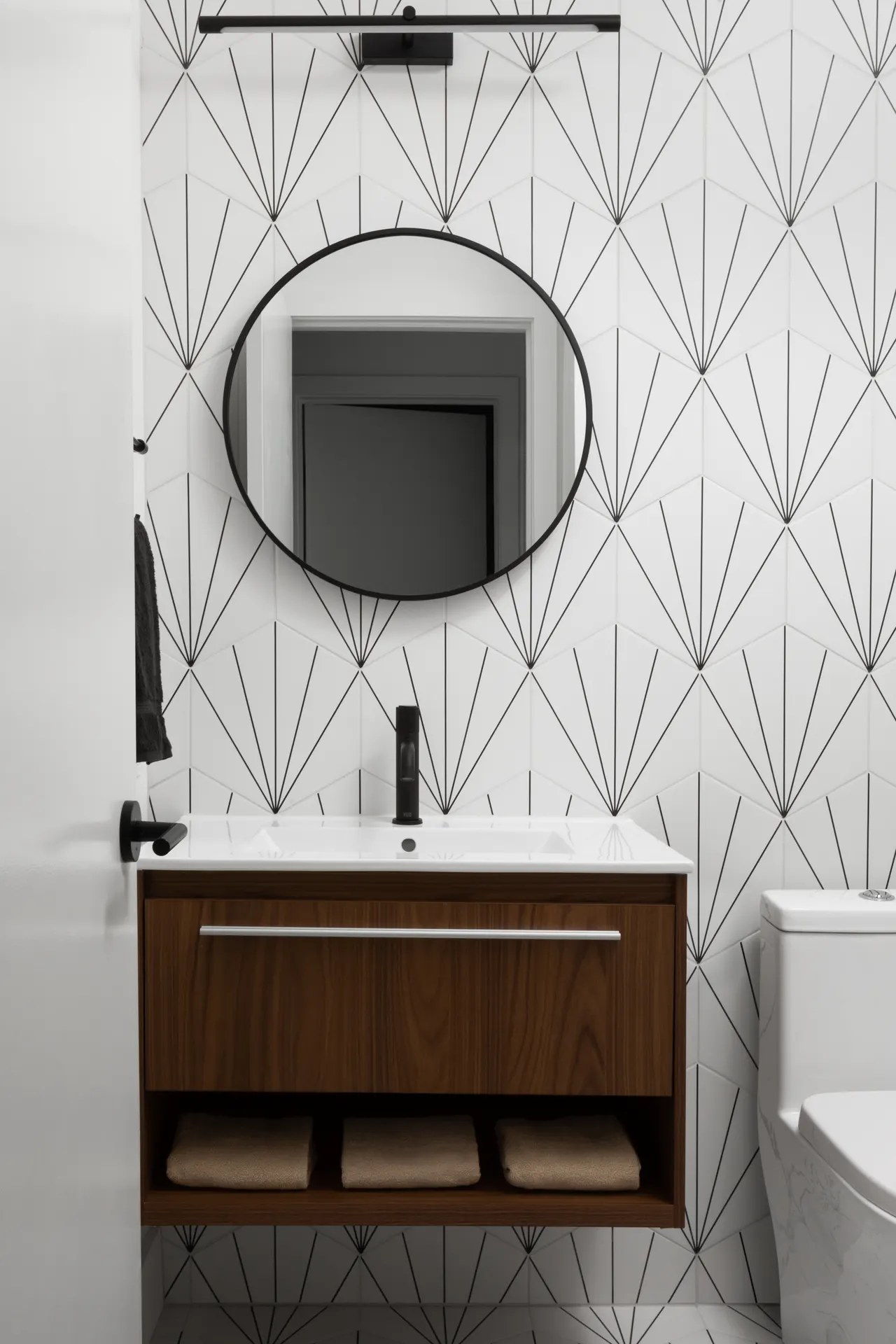 Powder room with graphic fan tile and round mirror