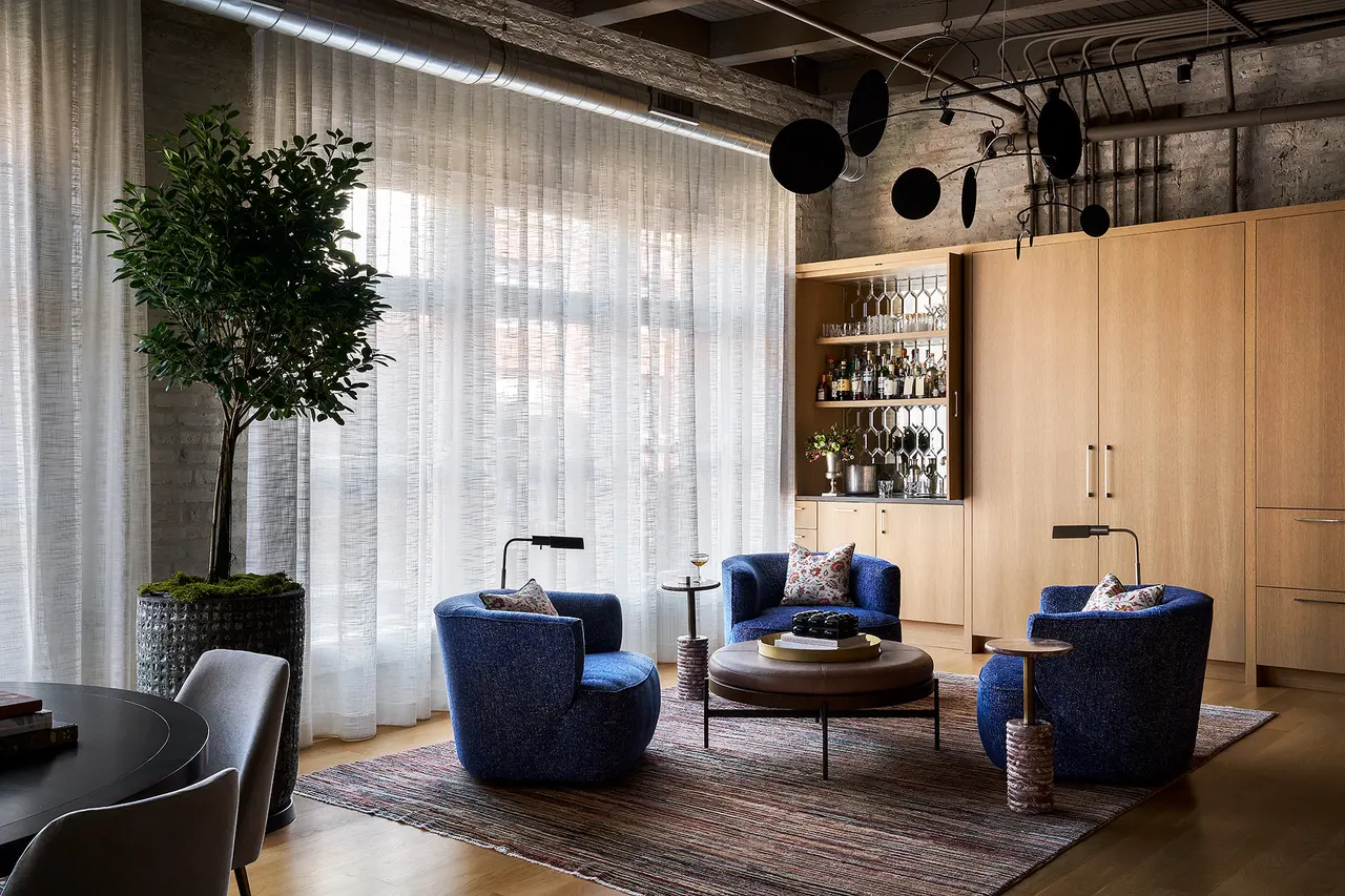 Seating area by sheer-draped loft windows