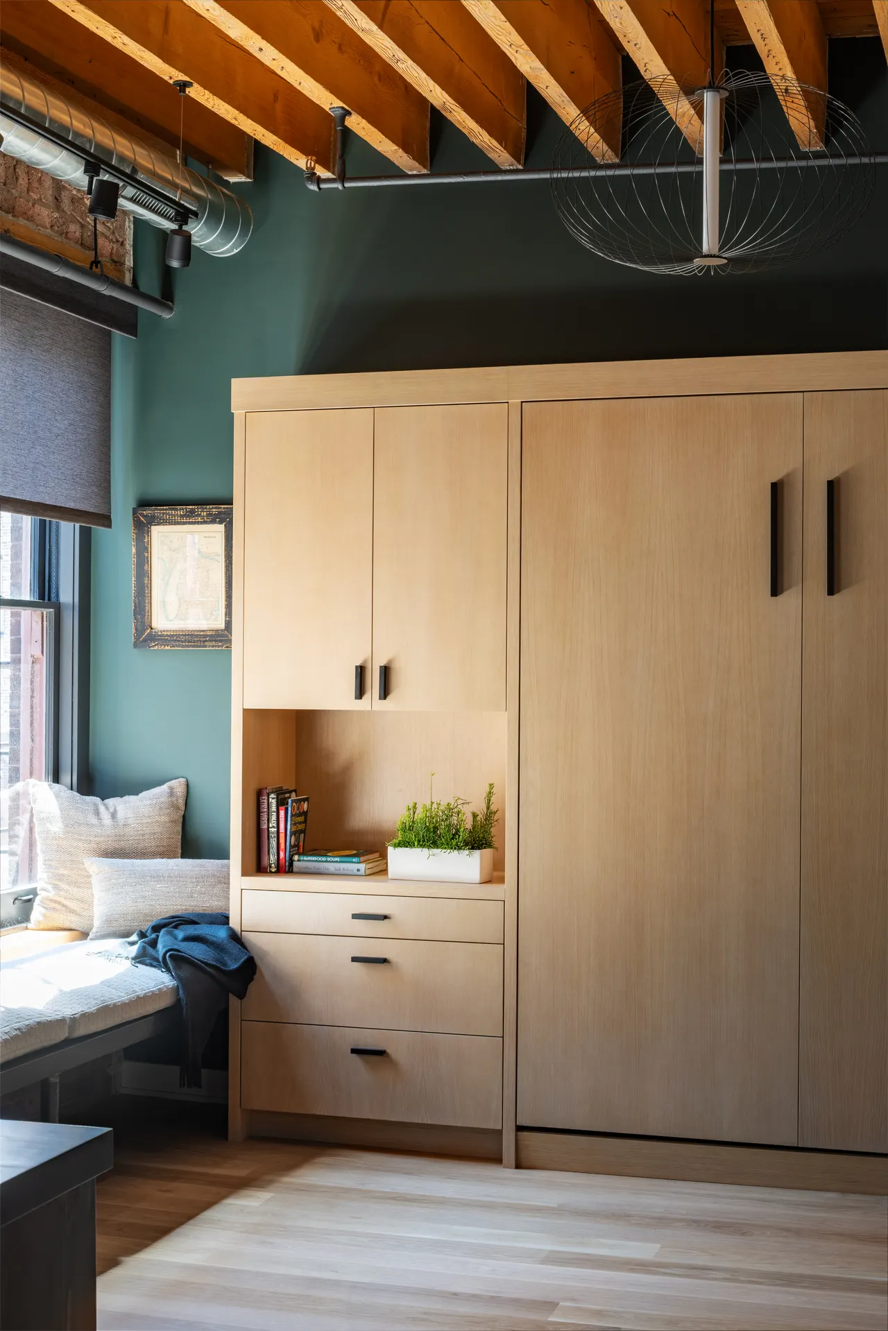Built-in wardrobe cabinetry against a teal wall