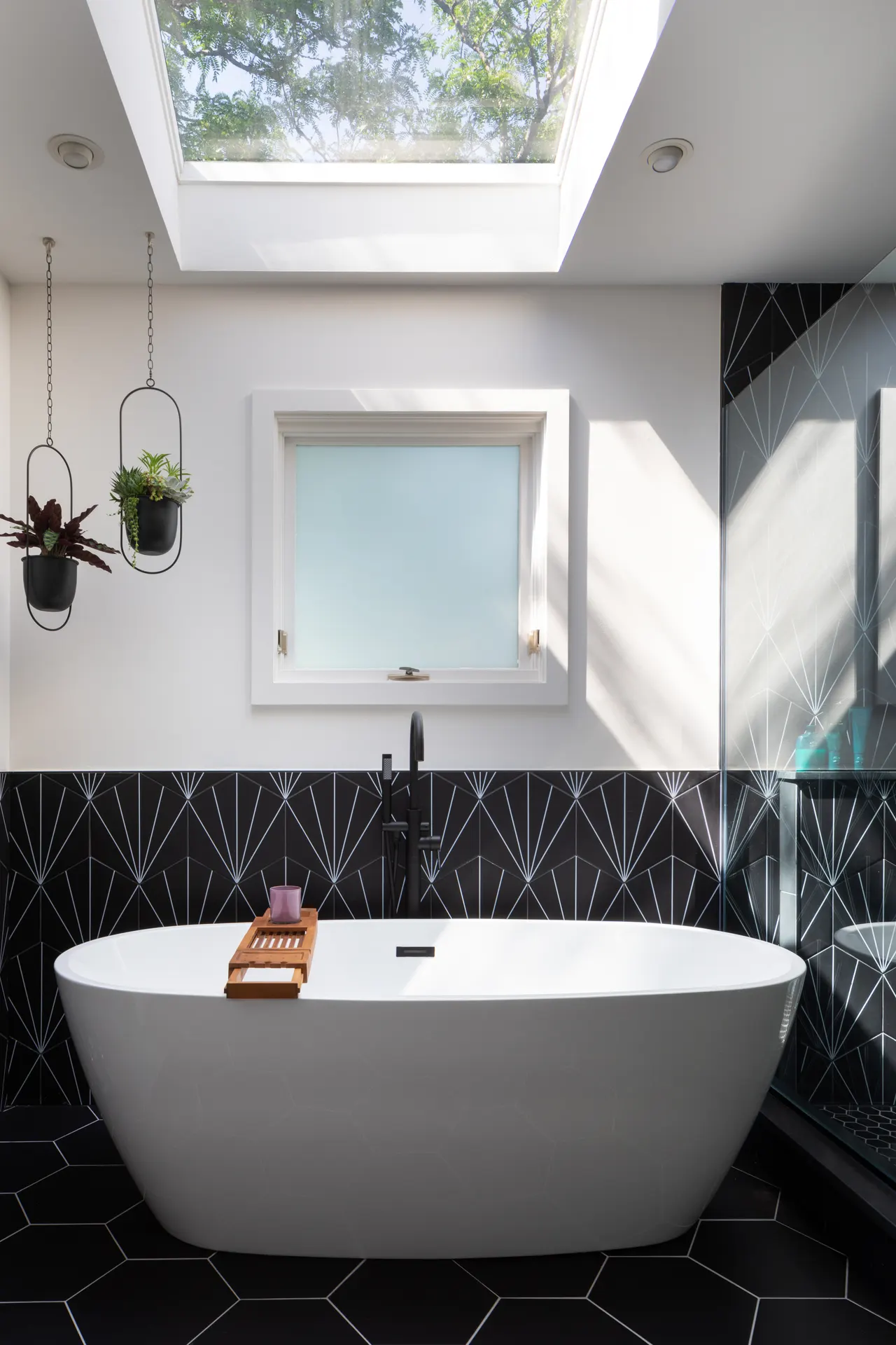 Primary bath with freestanding tub and black-and-white fan tile