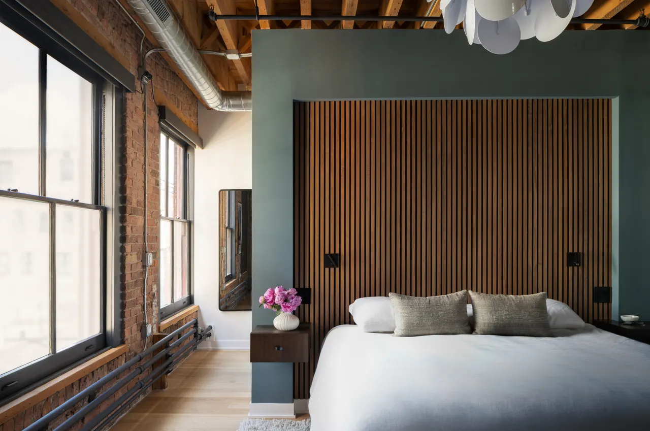 Bedroom with a slatted wood headboard wall and teal accent