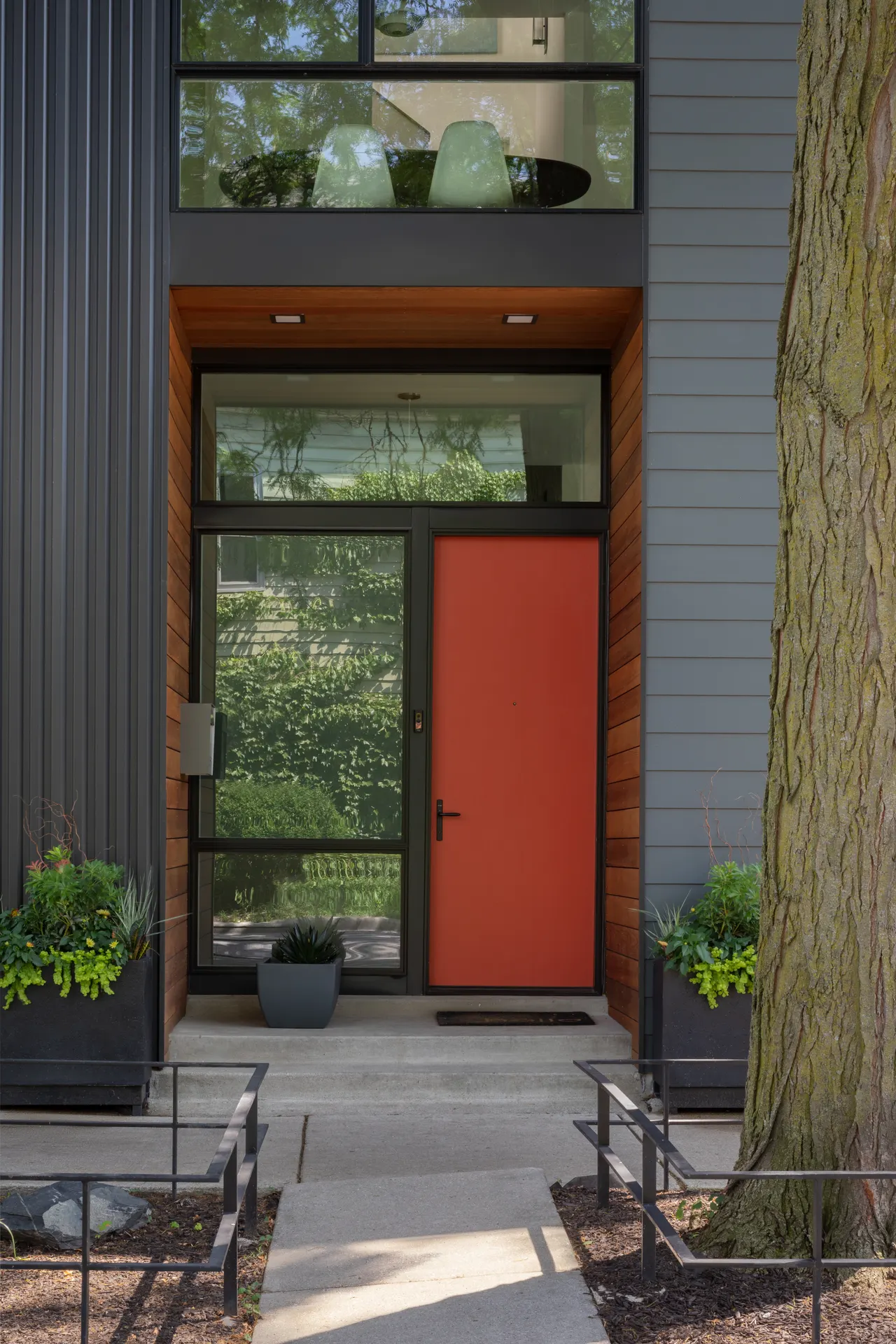 Entry with red door, cedar surround and full-height glazing
