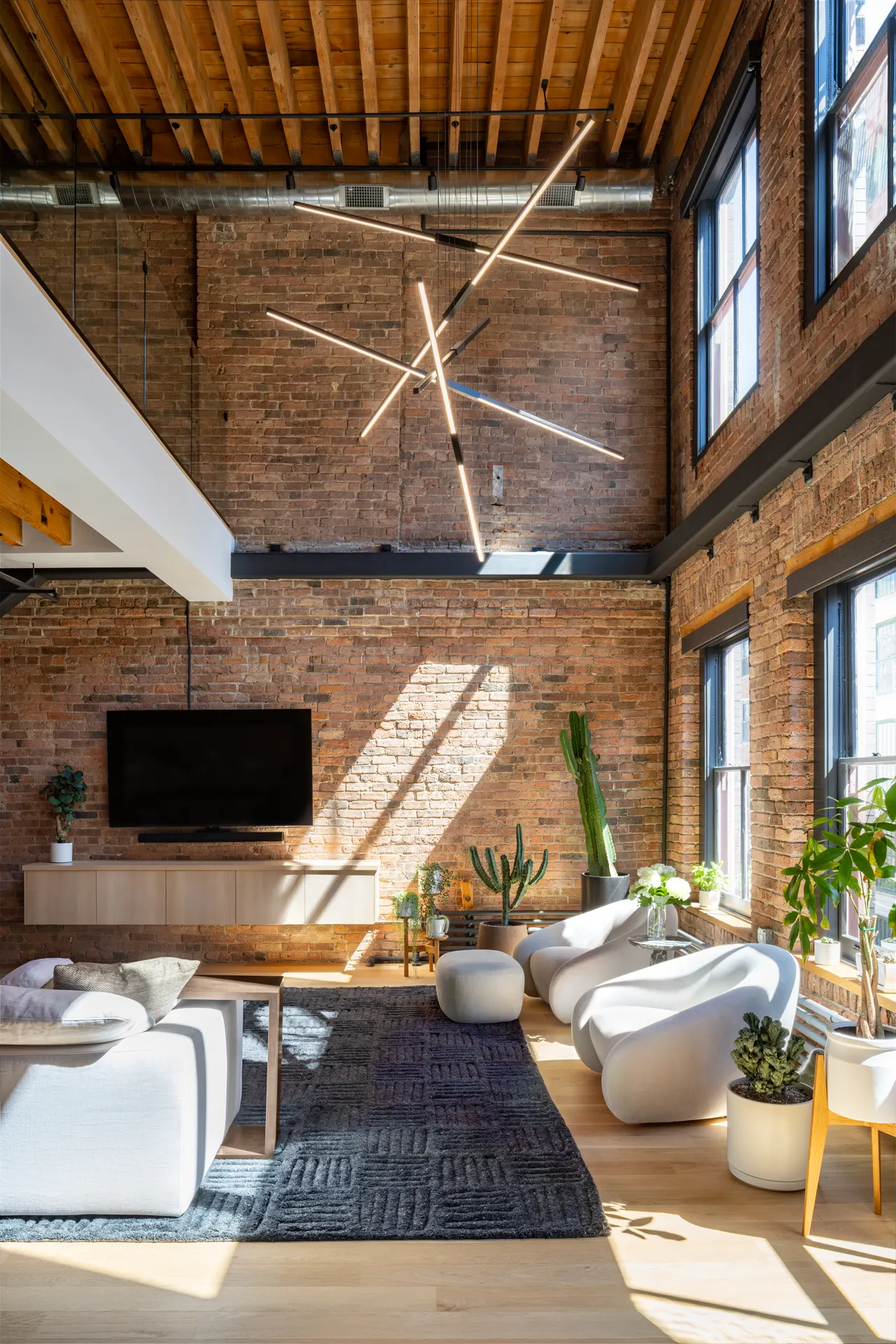 Living area beneath a starburst light fixture and timber ceiling