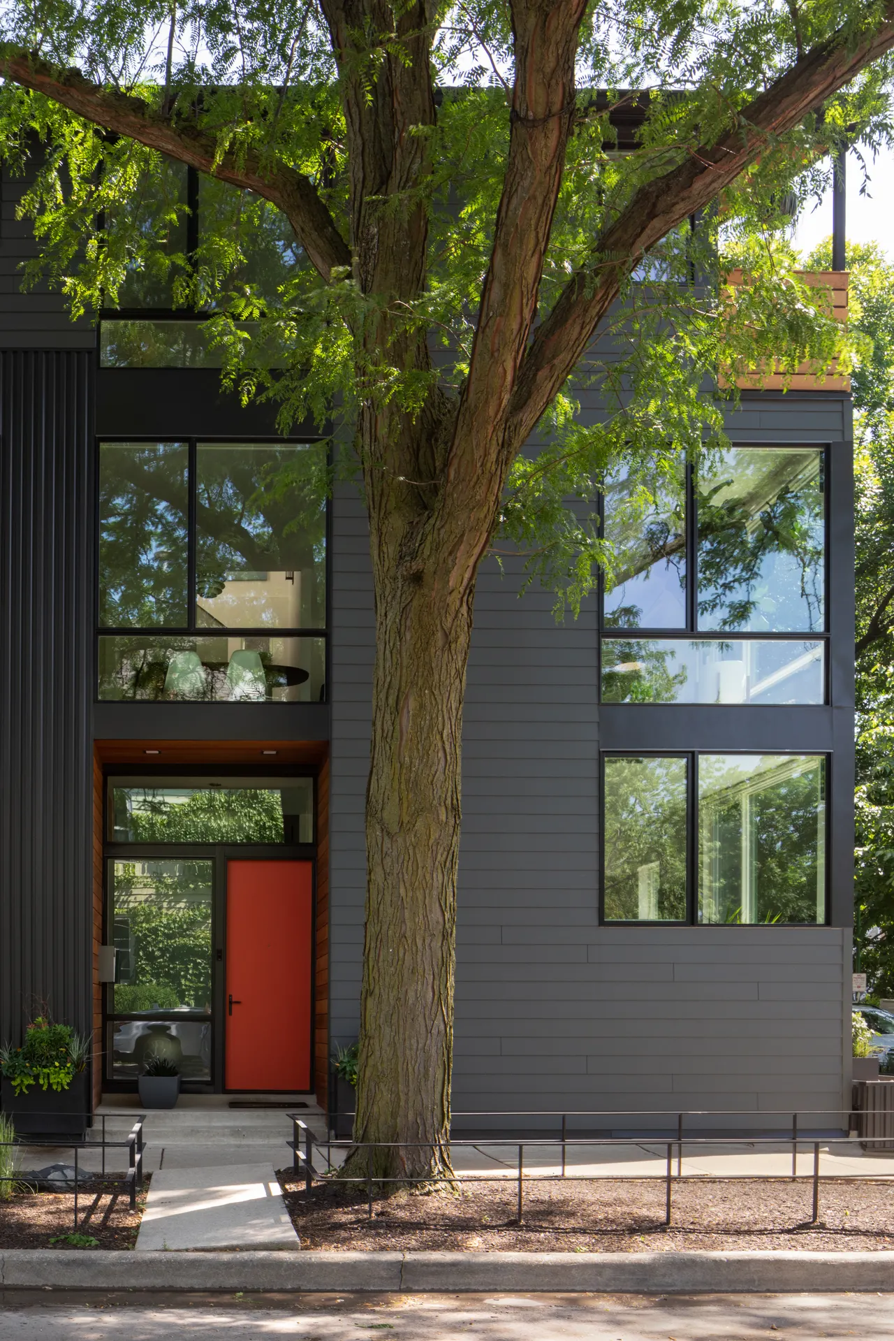 Front facade with black-framed windows and cedar-trimmed entry
