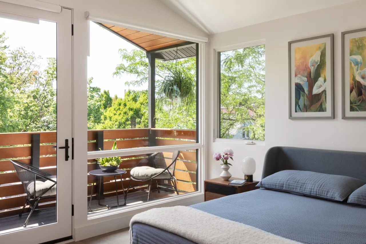 Primary bedroom opening to a covered balcony