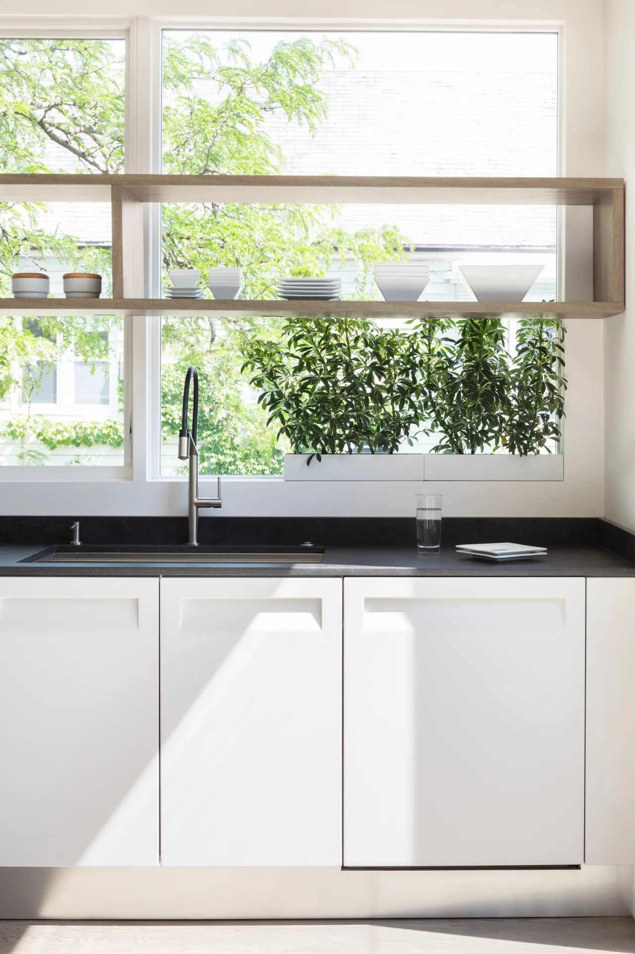 Kitchen sink under a wide window with plant ledge